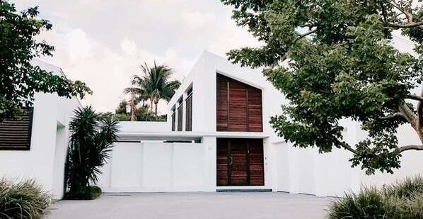 Exterior of a modern architecture home white with brown doors photo taken from the driveway